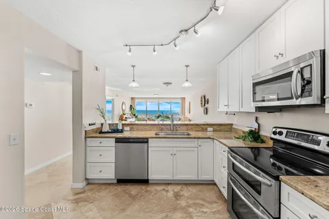 a spacious bathroom with a granite countertop double vanity sink a mirror and a shower