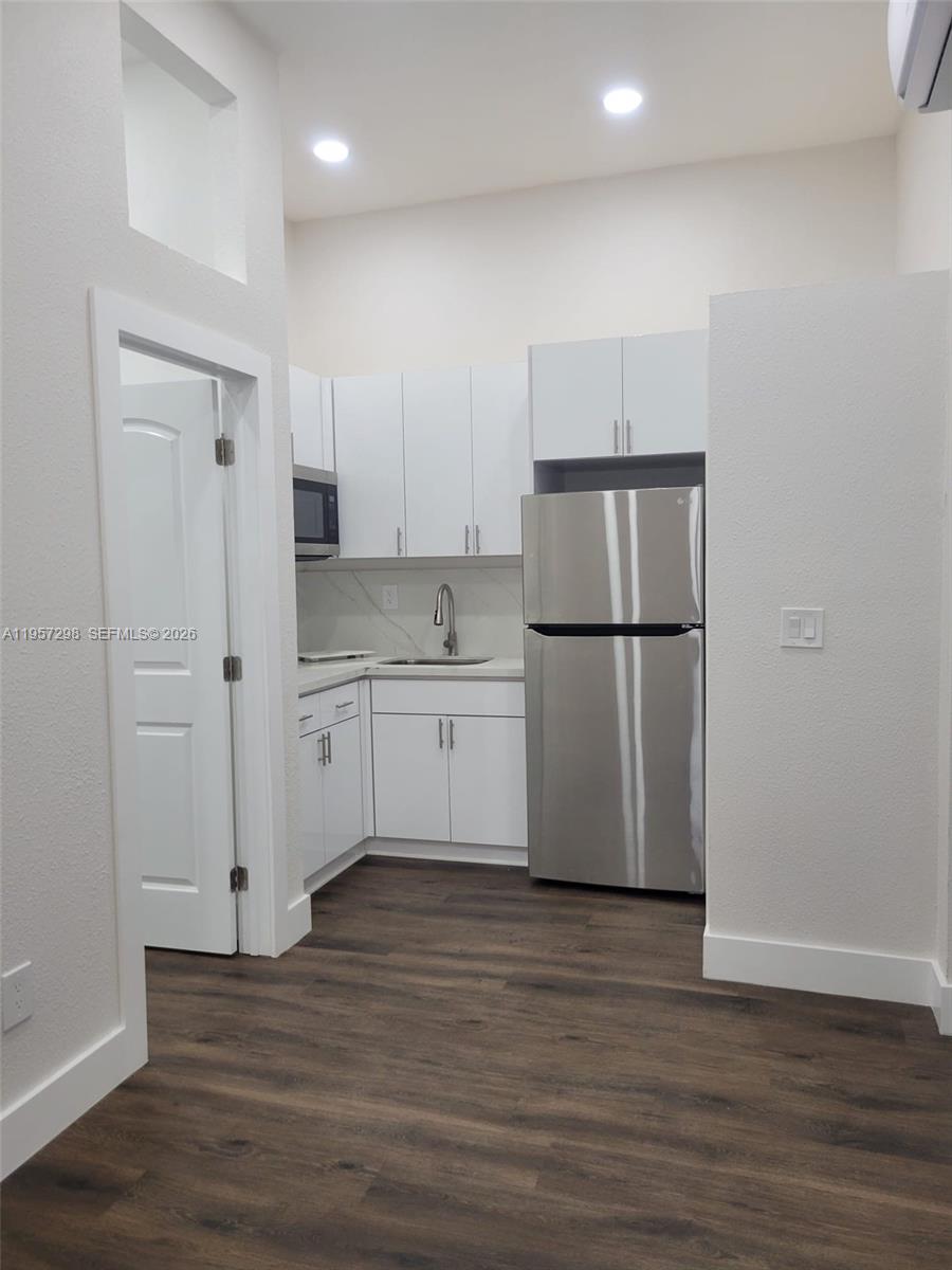 14200 Southwest 160th Court Miami, FL 33196 - Photo 25 of 36 a kitchen with a refrigerator a sink and a stove top oven