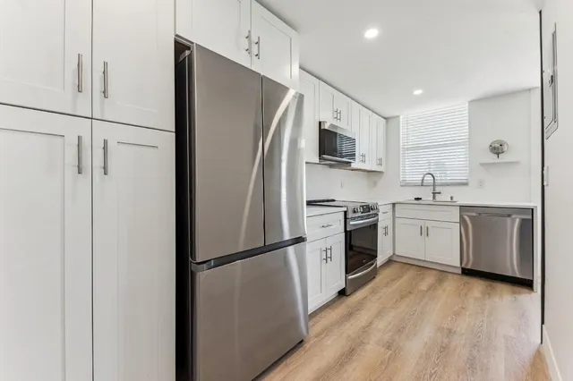 a kitchen with stainless steel appliances a refrigerator sink and microwave