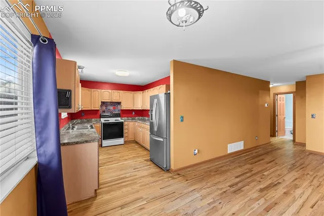 a kitchen view with a refrigerator and a stove