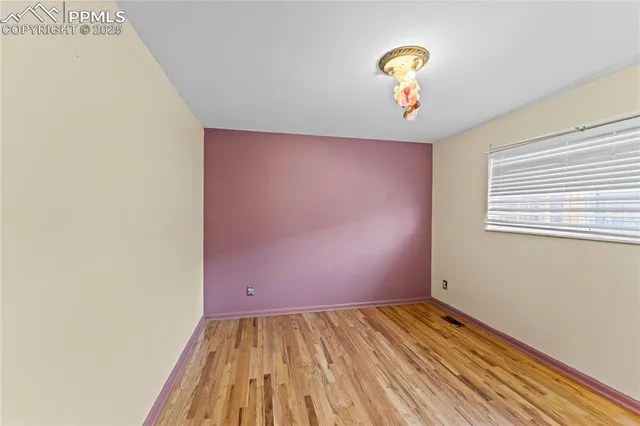 a view of a room with wooden floor and a ceiling fan