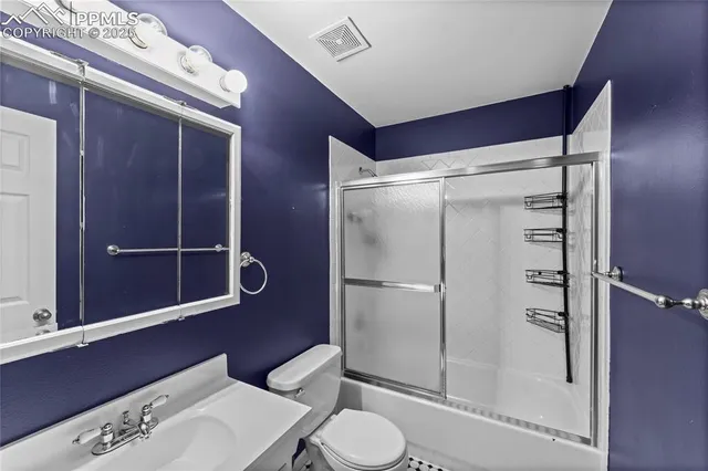 a bathroom with a toilet a sink and shower