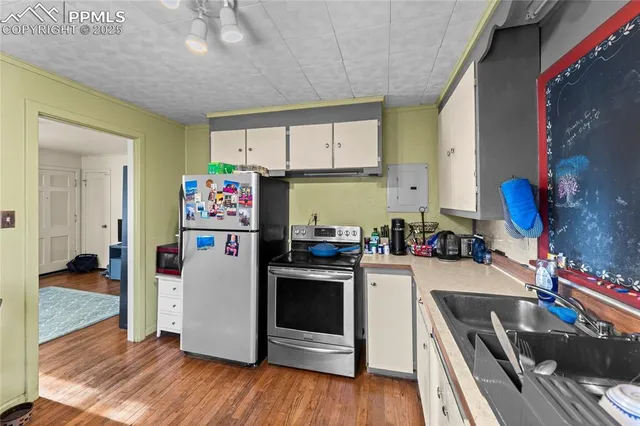 a kitchen with a refrigerator a stove and wooden floor
