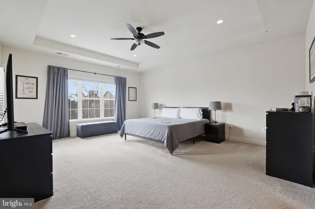 a spacious bedroom with a bed and a chandelier