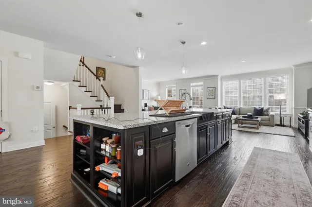 a large kitchen with stainless steel appliances granite countertop a lot of cabinets and wooden floor