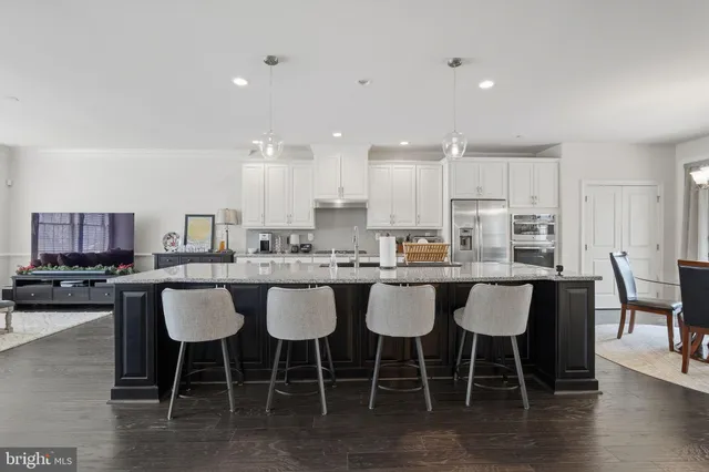 a kitchen with a dining table chairs and view living room
