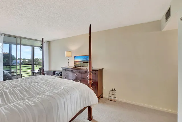 a bedroom with a bed and large window