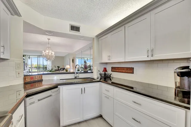 a kitchen with granite countertop white cabinets and white appliances