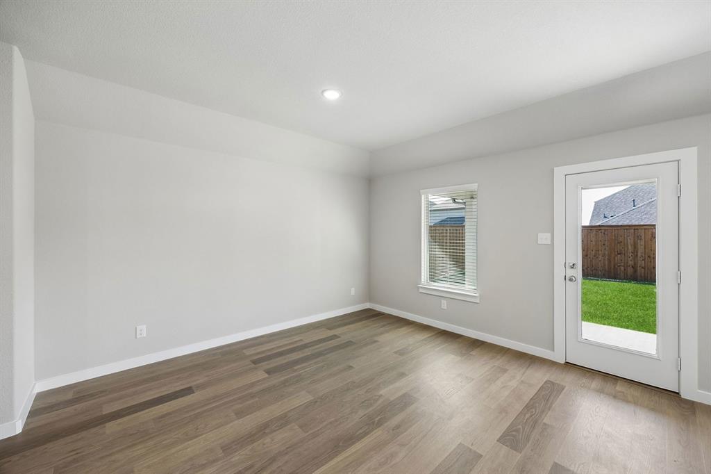 1424 Companero Street Haslet, TX 76052 - Photo 10 of 33 a view of an empty room with wooden floor and a window