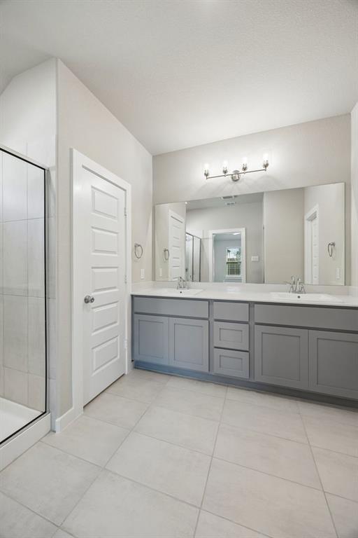 1424 Companero Street Haslet, TX 76052 - Photo 20 of 33 a bathroom with a vanity a sink a mirror and a bathtub