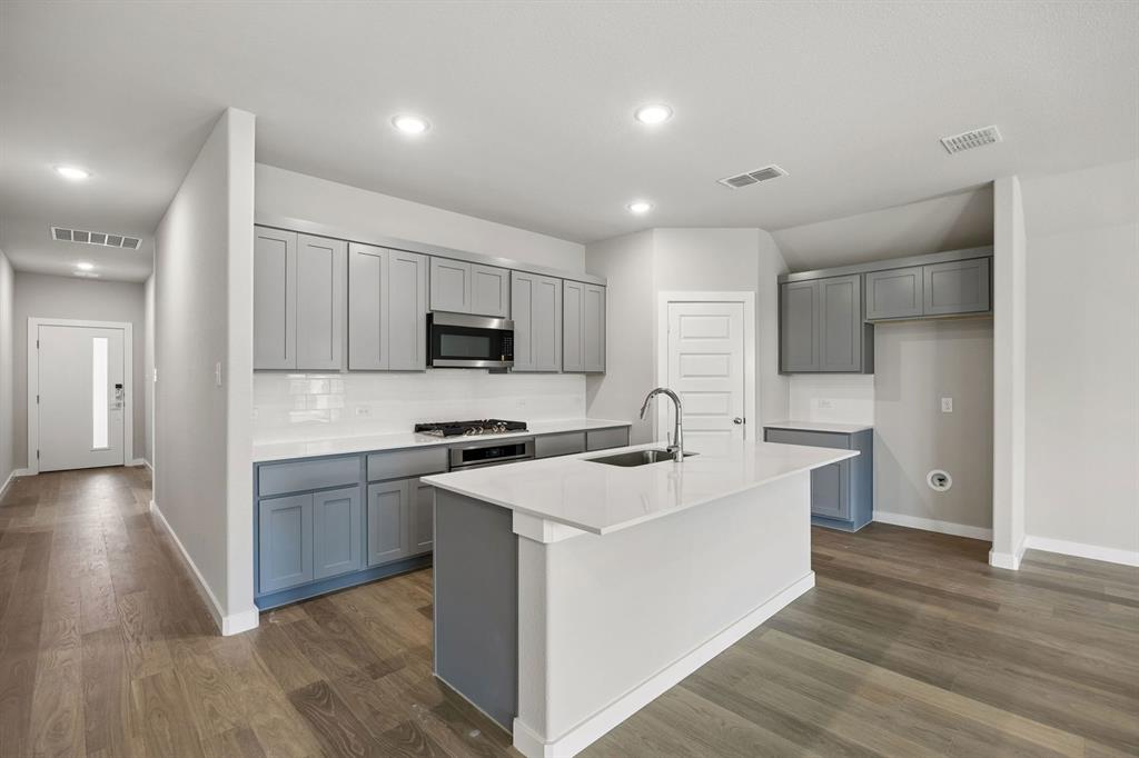 1424 Companero Street Haslet, TX 76052 - Photo 6 of 33 a kitchen with stainless steel appliances a sink stove and refrigerator