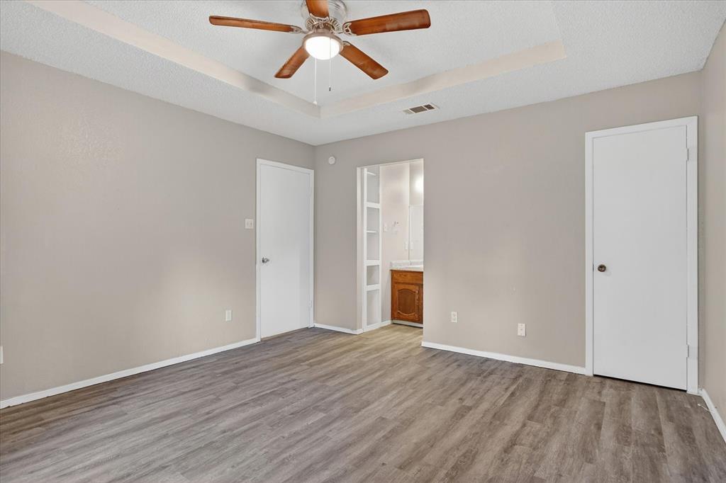 119 Del Rio Avenue, Unit C Benbrook, TX 76126 - Photo 13 of 17 an empty room with wooden floor fan and windows