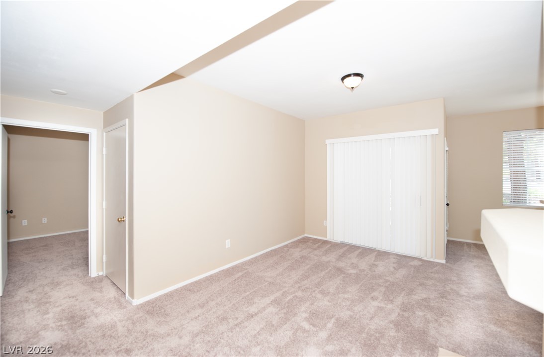 9050 West Warm Springs Road, Unit 1132 Las Vegas, NV 89148 - Photo 6 of 21 A spacious room offers comfortable carpeting and natural light through a large sliding glass door.
