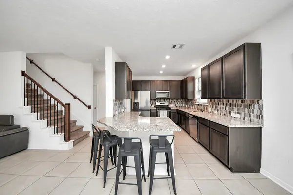 a kitchen with stainless steel appliances kitchen island granite countertop a sink and cabinets