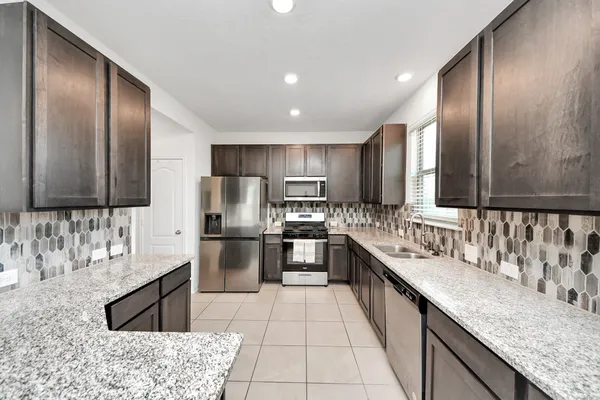 a kitchen with a sink stove top oven and cabinets