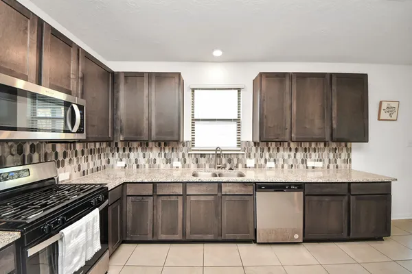 a large kitchen with a sink and cabinets