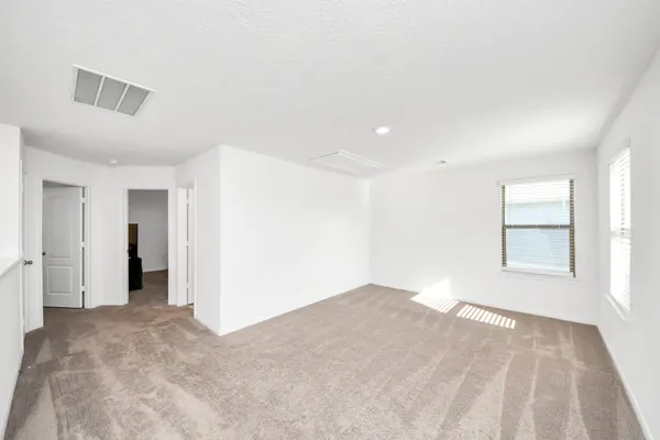 a spacious bedroom with a bed and a ceiling fan