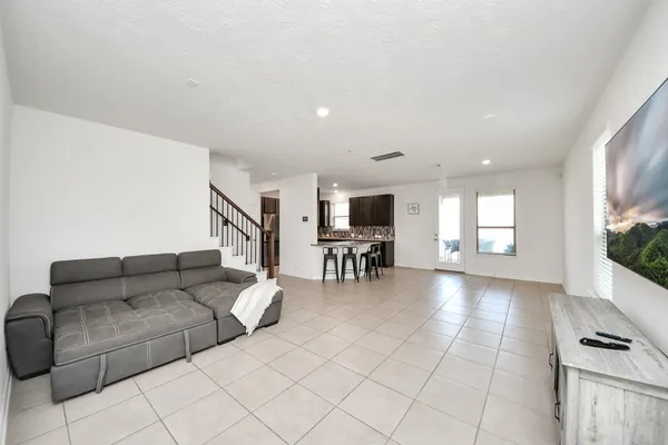 a living room with furniture and a dining table with kitchen view