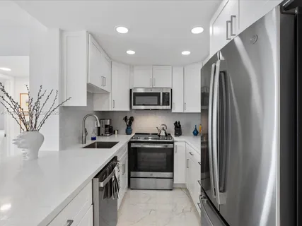 a kitchen with a refrigerator sink and stove top oven