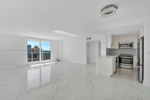 a kitchen with stainless steel appliances granite countertop a refrigerator sink and stove
