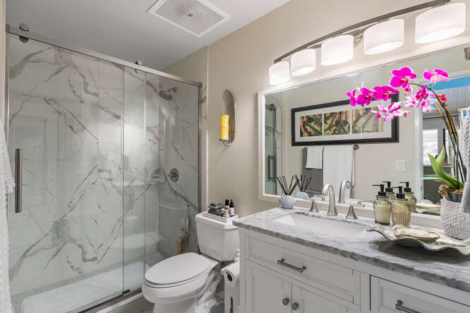 79-7199 Kona Coffee Villas, Unit 315 Holualoa, HI 96725 - Photo 18 of 28 a bathroom with a granite countertop sink mirror toilet and shower