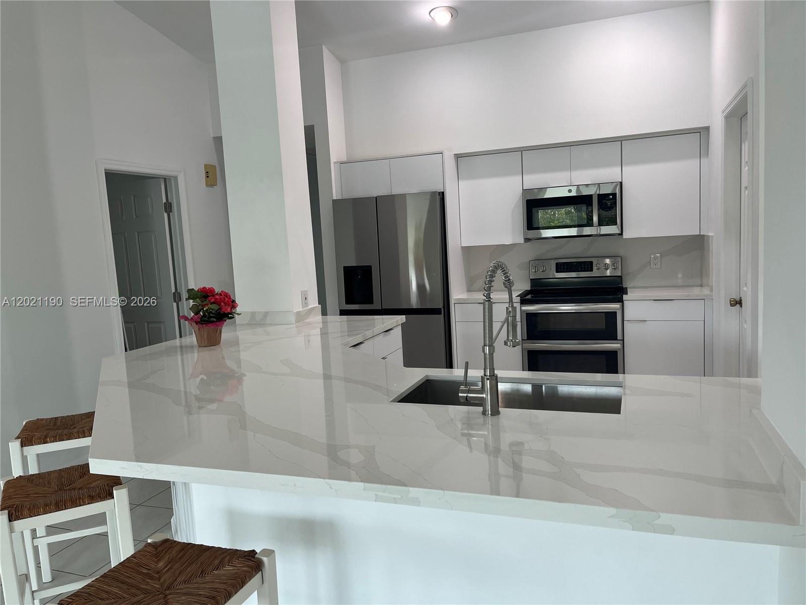814 Heron Road Weston, FL 33326 - Photo 21 of 27 a kitchen with stainless steel appliances kitchen island granite countertop a refrigerator and cabinets