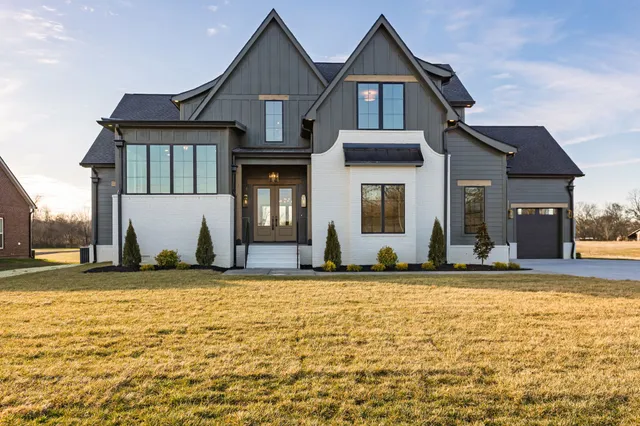 a view of a brick house with a yard in front of it