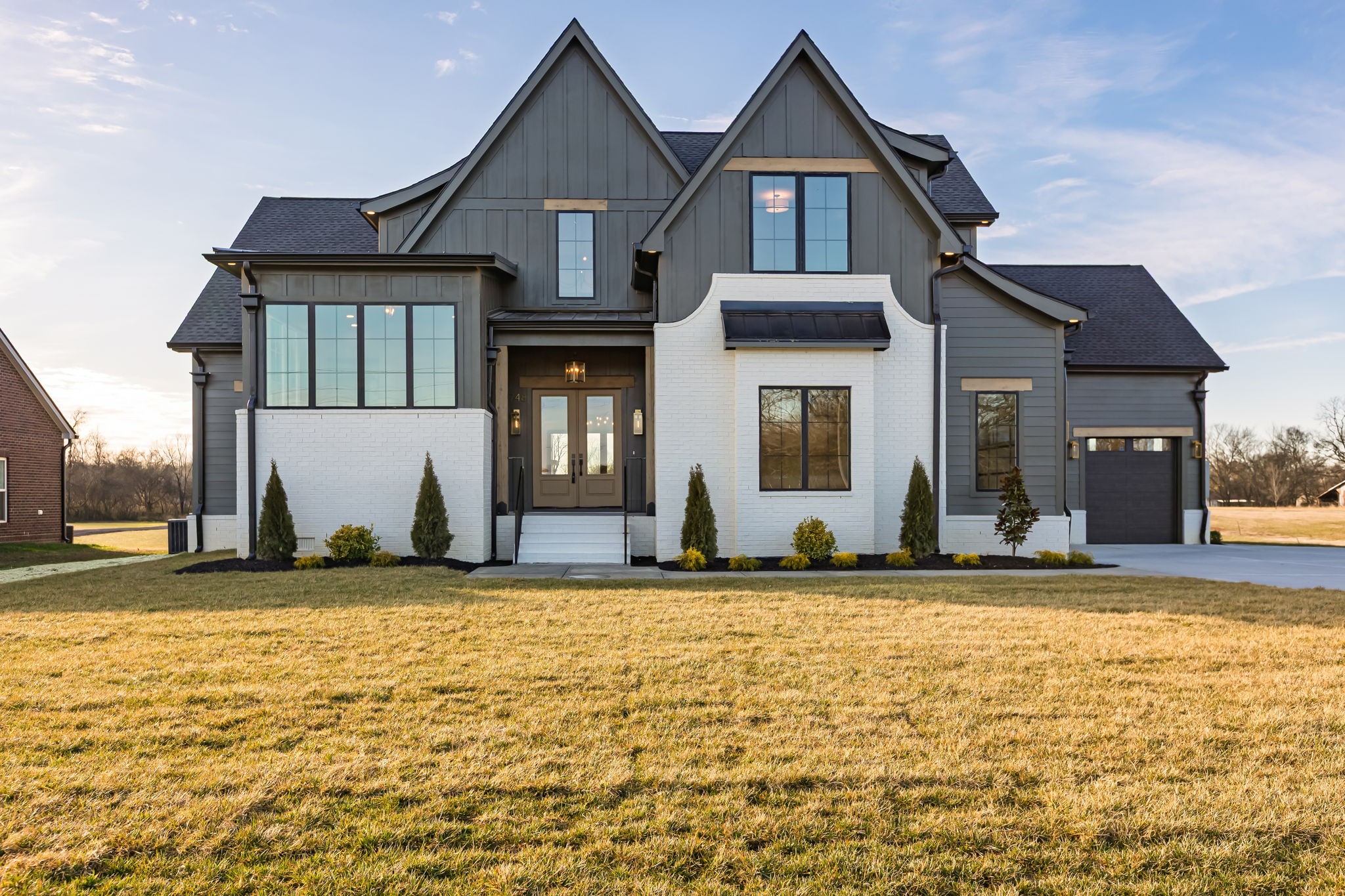 a view of a brick house with a yard in front of it