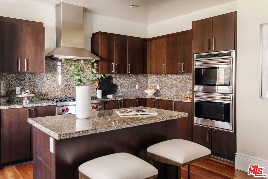 10800 Wilshire Boulevard, Unit 502 Los Angeles, CA 90024 - Photo 10 of 29 a kitchen with a sink a stove a microwave and cabinetry