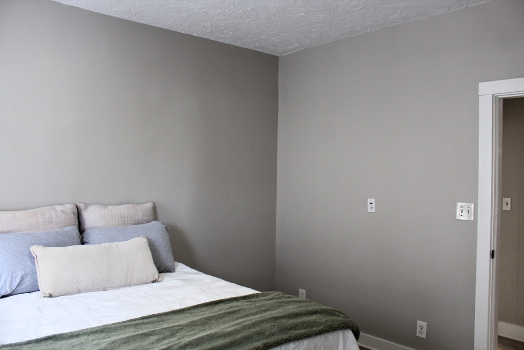 4 Northend Street, Unit 1 Peabody, MA 01960 - Photo 9 of 11 a bedroom with a bed and a night stand