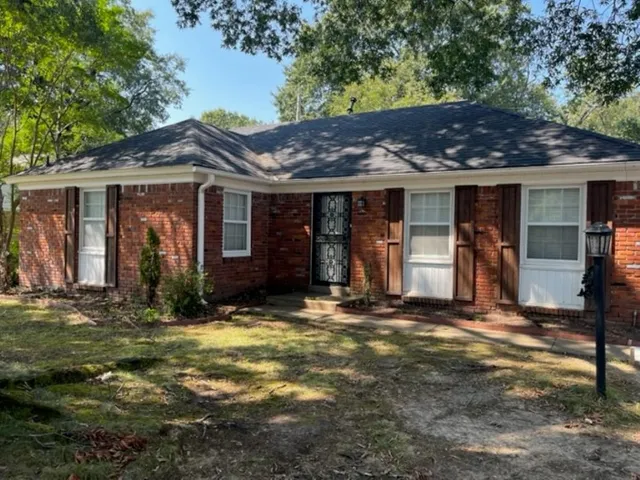 a view of a house with large windows and a lawn chairs