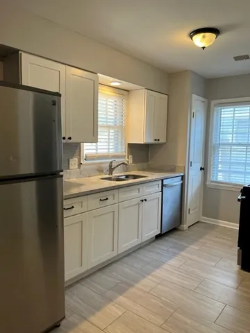 a kitchen with a refrigerator a sink and a window