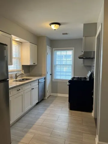 a kitchen with granite countertop a refrigerator and a sink