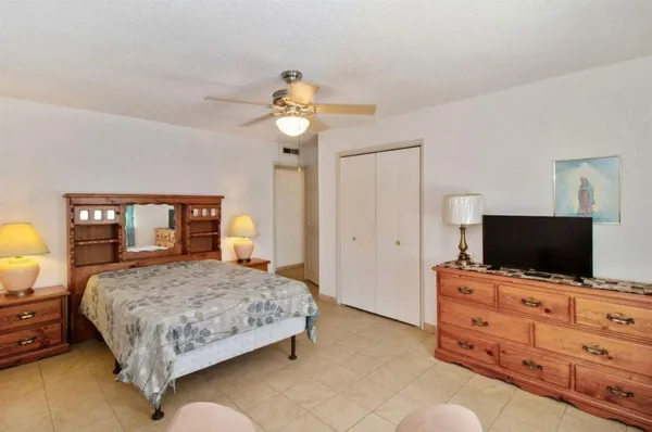 a bedroom with a bed and a flat tv screen on dresser