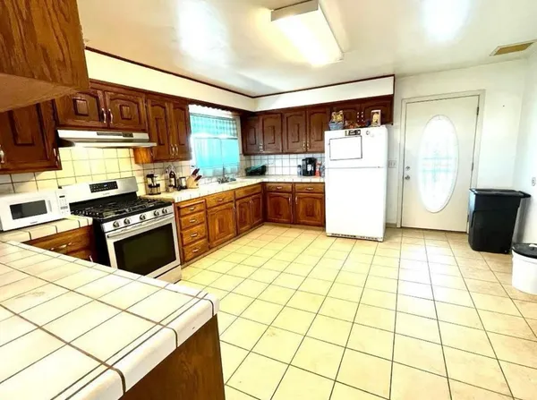 a kitchen with stainless steel appliances granite countertop a stove a sink dishwasher and a refrigerator