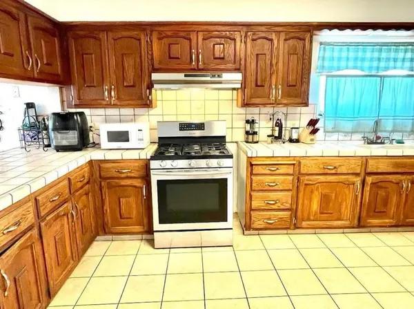 a kitchen with stainless steel appliances a stove a sink and a microwave