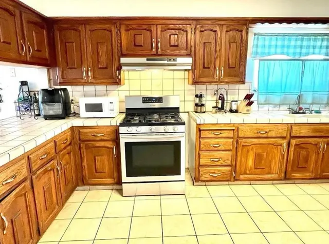 a kitchen with stainless steel appliances a stove a sink and a microwave