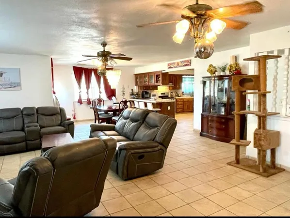 a living room with furniture a chandelier and a flat screen tv