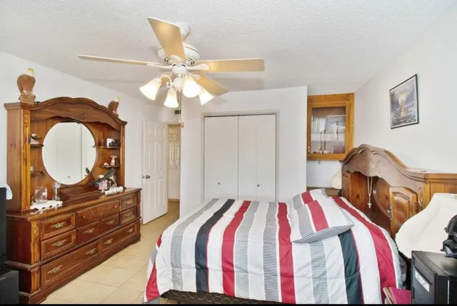 a bedroom with a bed and a mirror on a dresser