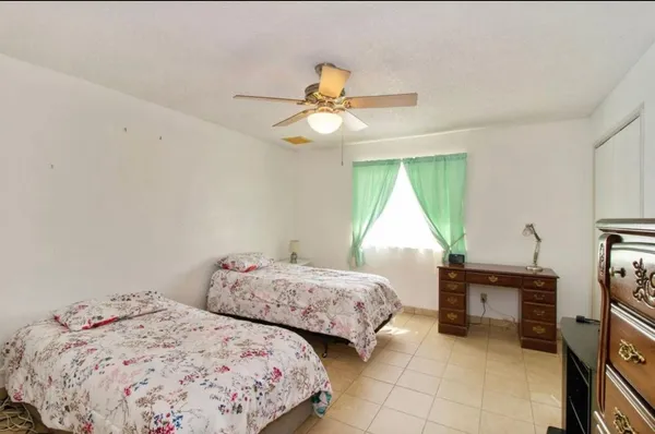 a bedroom with two beds and a chandelier