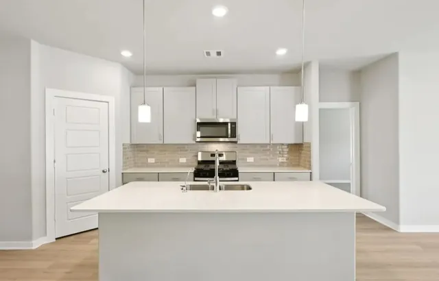 a kitchen with a appliances a sink and a counter top space