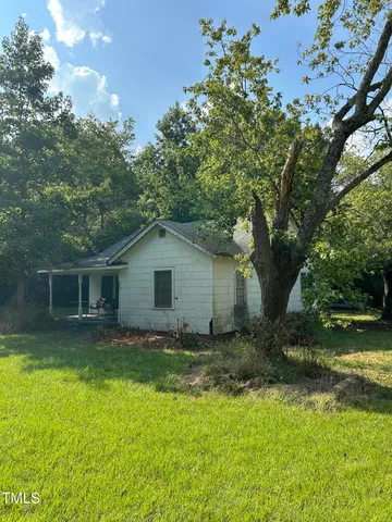 a view of backyard of house with green space
