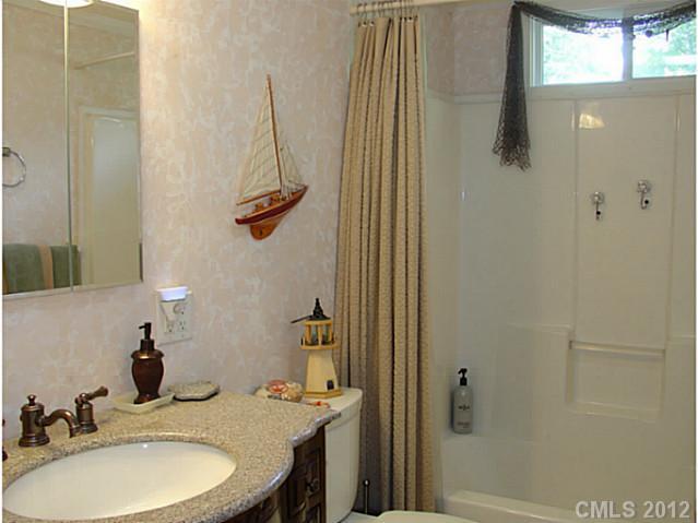 8109 Pine Oak Road Waxhaw, NC 28173 - Photo 11 of 16 a bathroom with a sink a mirror and a shower