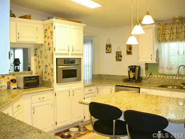 8109 Pine Oak Road Waxhaw, NC 28173 - Photo 4 of 16 a kitchen with granite countertop a sink and chairs