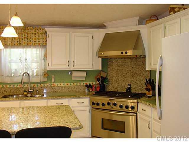 8109 Pine Oak Road Waxhaw, NC 28173 - Photo 5 of 16 a kitchen with a stove a refrigerator and a sink