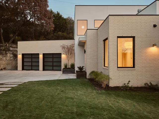 a living room with furniture large windows and wooden floor