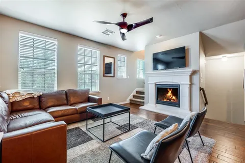 a living room with furniture a flat screen tv and a fireplace