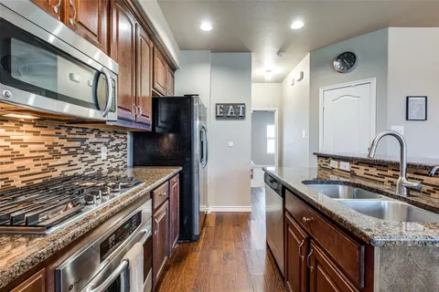 a kitchen with stainless steel appliances granite countertop a sink stove and refrigerator