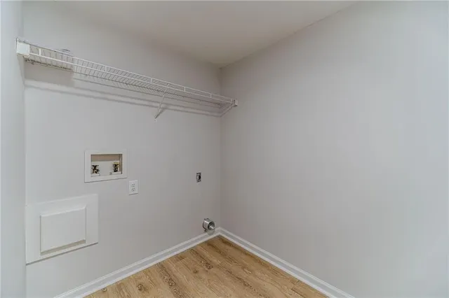 an empty room with wooden floor and ceiling fan
