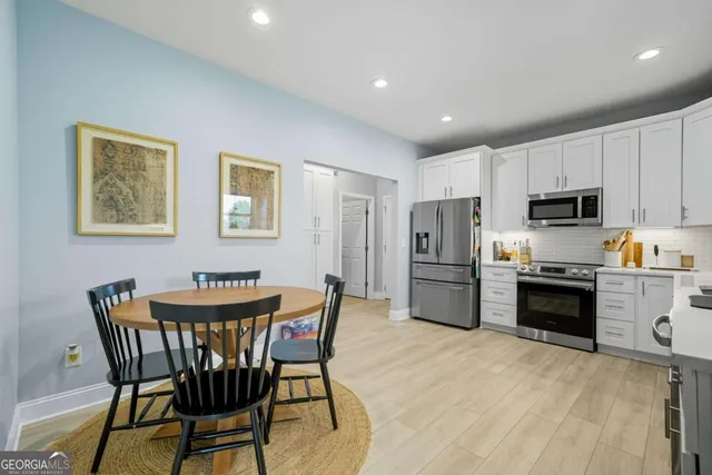 a kitchen with stainless steel appliances a refrigerator stove microwave and white cabinets